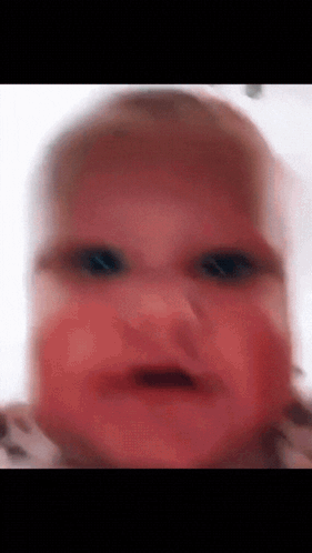 a blurry picture of a baby 's face with red eyes