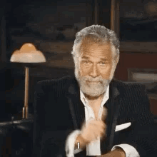 An older man in a tuxedo gives an approving thumbs-up.