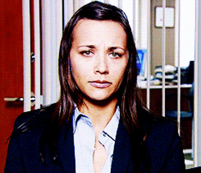 Karen Filippelli from The Office looks straight ahead with a restrained expression.