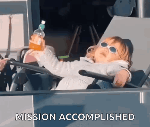 A child in sunglasses lounges in a vehicle seat while holding a drink, captioned “MISSION ACCOMPLISHED.”