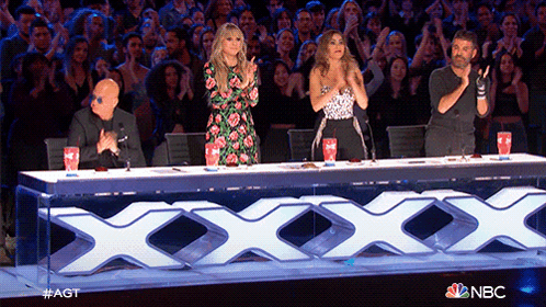 a group of people are sitting at a table with a nbc logo on it