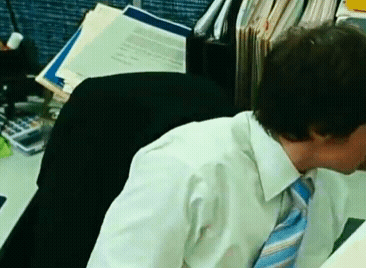 a man in a tie sits at a desk with a calculator