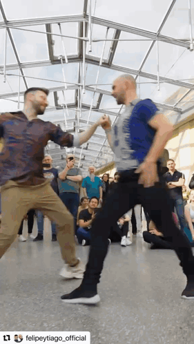two men are dancing in front of a crowd and they are sponsored by felipetytiago_official