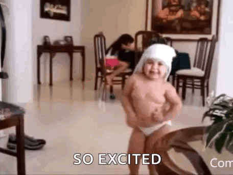 A diapered baby dances in a living room with “SO EXCITED” text.