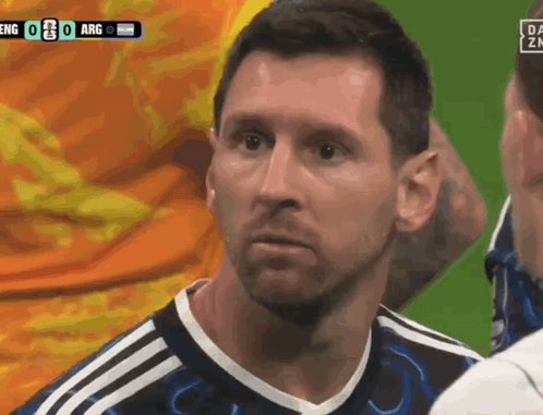 A soccer player in an Argentina jersey stares with a concerned, stunned expression.