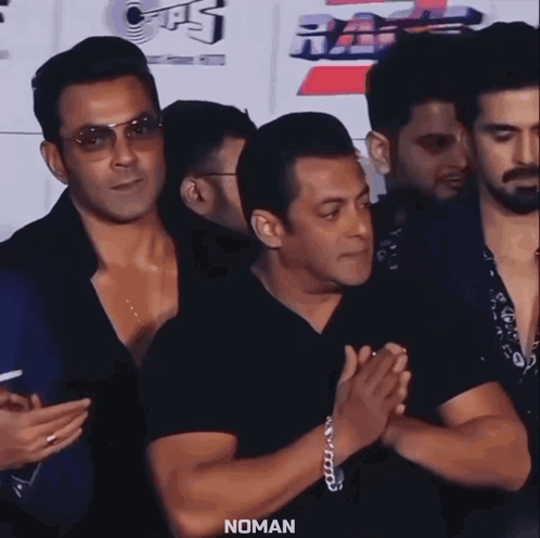 a group of men standing next to each other with the word noman on the bottom left