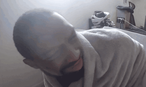 a man wrapped in a white blanket with his mouth open