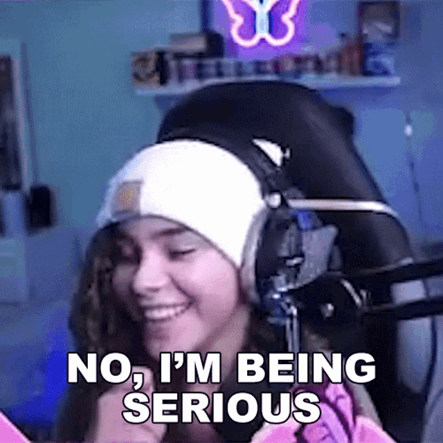 a woman wearing headphones and a beanie says no i 'm being serious .