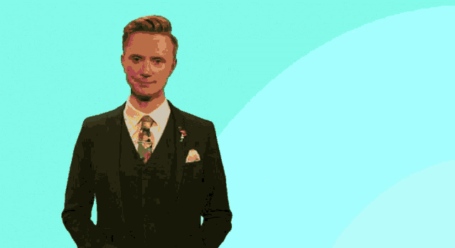 a man in a suit and tie is standing in front of a pink and yellow circle