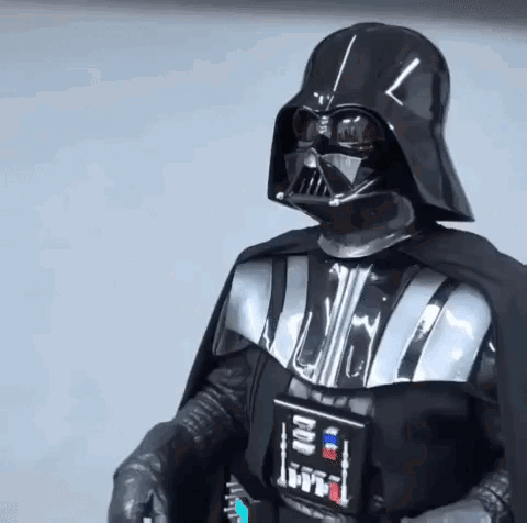 Darth Vader stands in armor and gives a thumbs up.
