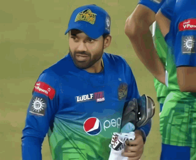 a man wearing a blue and green jersey with pepsi on it