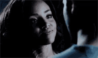 a man and a woman are hugging each other in the dark .