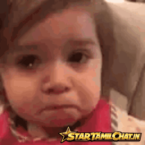 A young child looks sadly toward the camera with watery eyes.