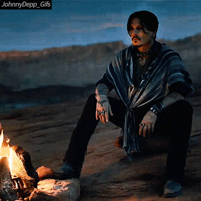 a gif of johnny depp sitting by a fire with the caption johnnydepp gifs