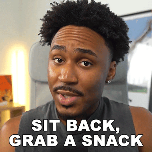 a man says sit back grab a snack while sitting in a chair