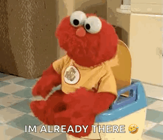 elmo from sesame street is sitting on a potty and saying `` i 'm already there '' .