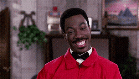 a man wearing a red jacket and a bow tie is smiling .