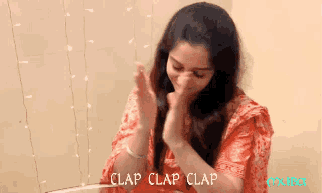 Woman in a patterned red outfit claps with the caption “CLAP CLAP CLAP.”