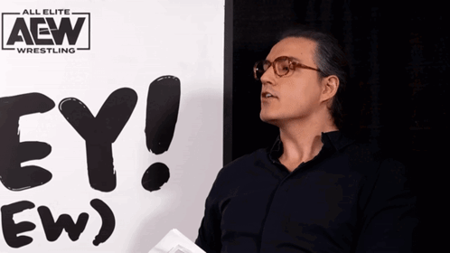 RJ City speaks beside the “HEY! (EW)” sign during an AEW interview.
