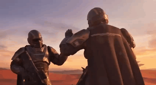 two soldiers in armor are giving each other a high five .