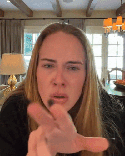 a woman with long blonde hair is making a funny face and pointing at the camera