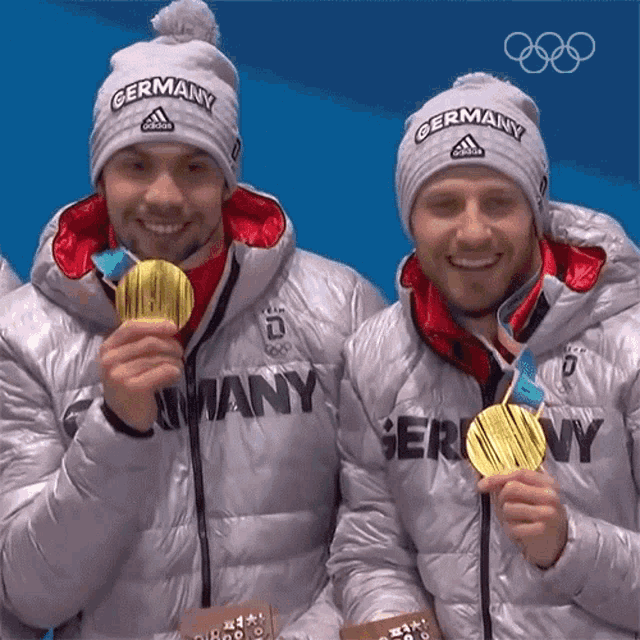 two athletes from germany hold up their medals