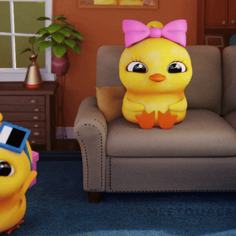 a yellow stuffed duck with a pink bow on its head sits on a couch
