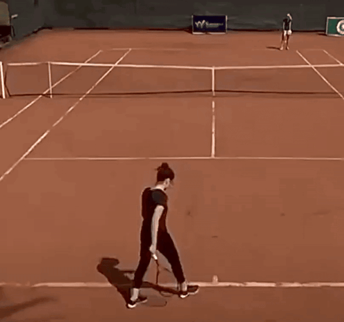a woman playing tennis on a court with a sign that says w