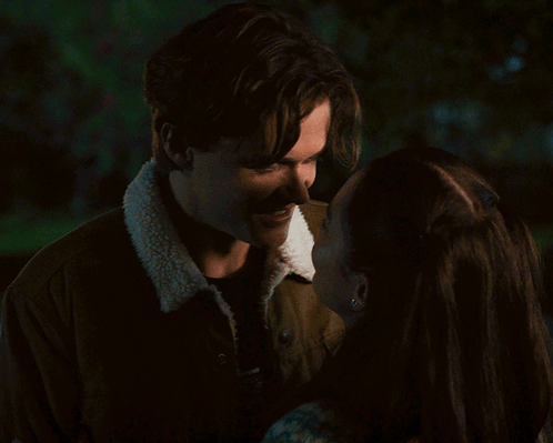 a man and woman are kissing in the dark