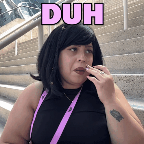 A woman sitting on outdoor steps touches her face beneath a pink “DUH” caption.