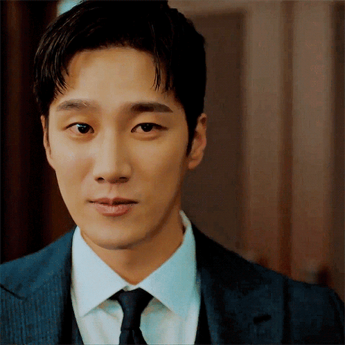 a man wearing a suit and tie looks at the camera