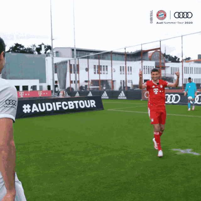 a soccer player is giving a thumbs up in front of an audi summer tour banner