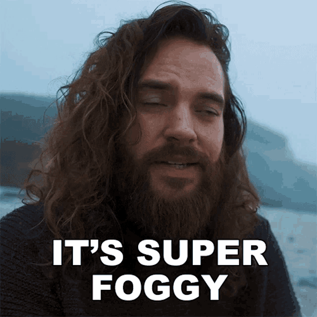 a man with long hair and a beard has the words it 's super foggy above him