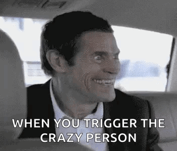 A man in a car smiles tensely with the caption “WHEN YOU TRIGGER THE CRAZY PERSON.”