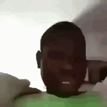a man with a beard is making a funny face while laying on a bed .