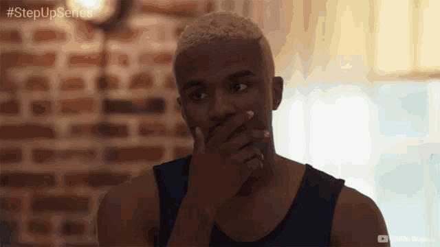 a man with blonde hair is covering his mouth with his hand and the hashtag stepupseries is above him