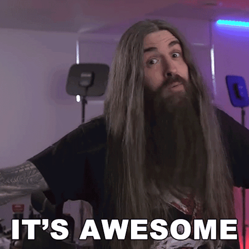 A long-haired man smiles in a purple-lit room with the caption “IT’S AWESOME.”