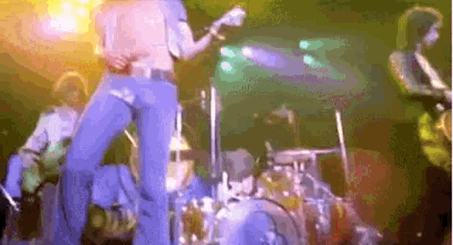 a group of people are playing instruments on a stage in a band .