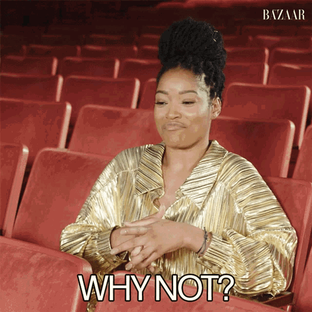 a woman in a gold dress is sitting in an auditorium with the words why not below her
