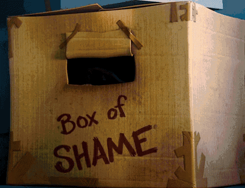 A cardboard “Box of Shame” has a dark opening for peeking out.