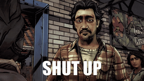 a man in a plaid shirt is standing in front of a brick wall with the words shut up above him