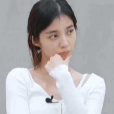 Woman in white rests her chin on her hand with a skeptical embarrassed look.