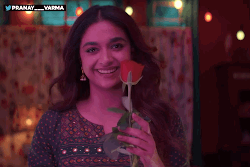 a woman is smiling while holding a red rose in front of a twitter logo