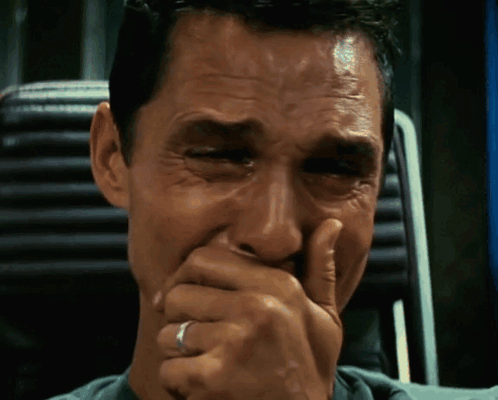 A man from Interstellar cries while covering his mouth with his hand.