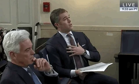 A man in a hearing room reacts with offended disbelief.