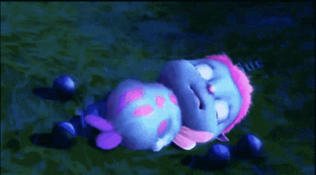a blue cartoon character with pink hair is sleeping in the grass