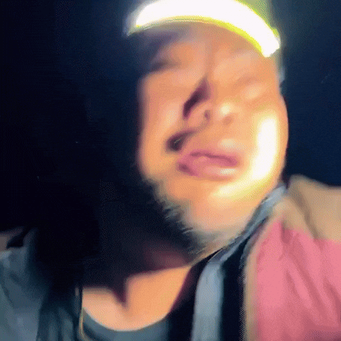a man with a beard wearing a hat with a yellow light on it