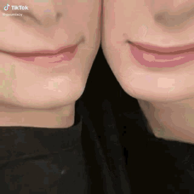 a close up of two people 's faces with their mouths together