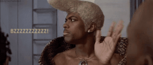 a man with blonde hair and a leopard print jacket is giving an ok sign .