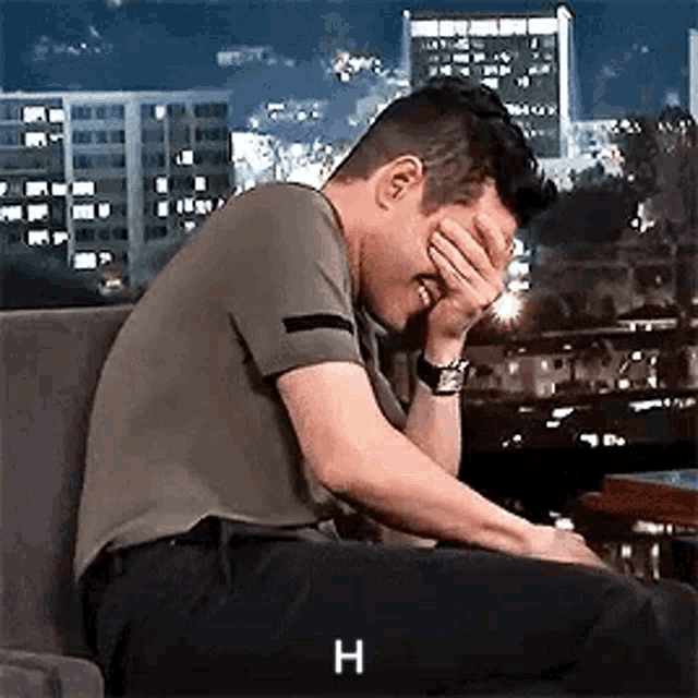 Man sits with his face in his hand, visibly embarrassed.